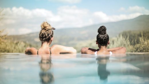 deux femmes accoudées au bord d'une piscine hors-sol